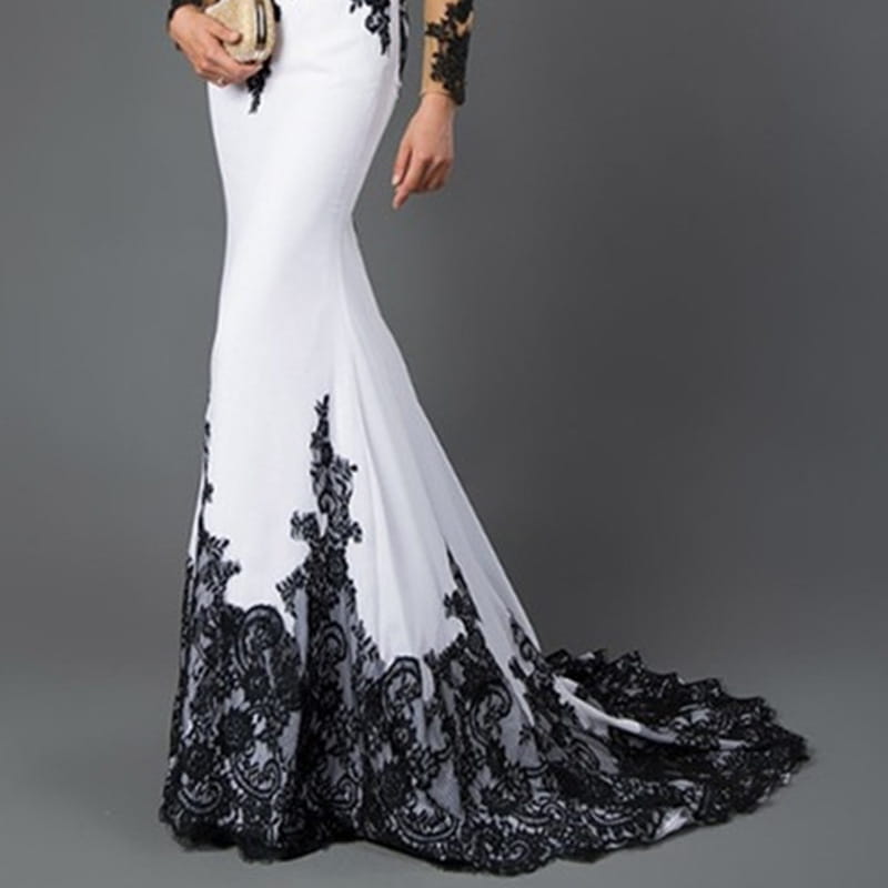a white embroidered lace maxi fishtail slim tail gown featuring intricate black lace detailing along the sides, sleeves, and hemline