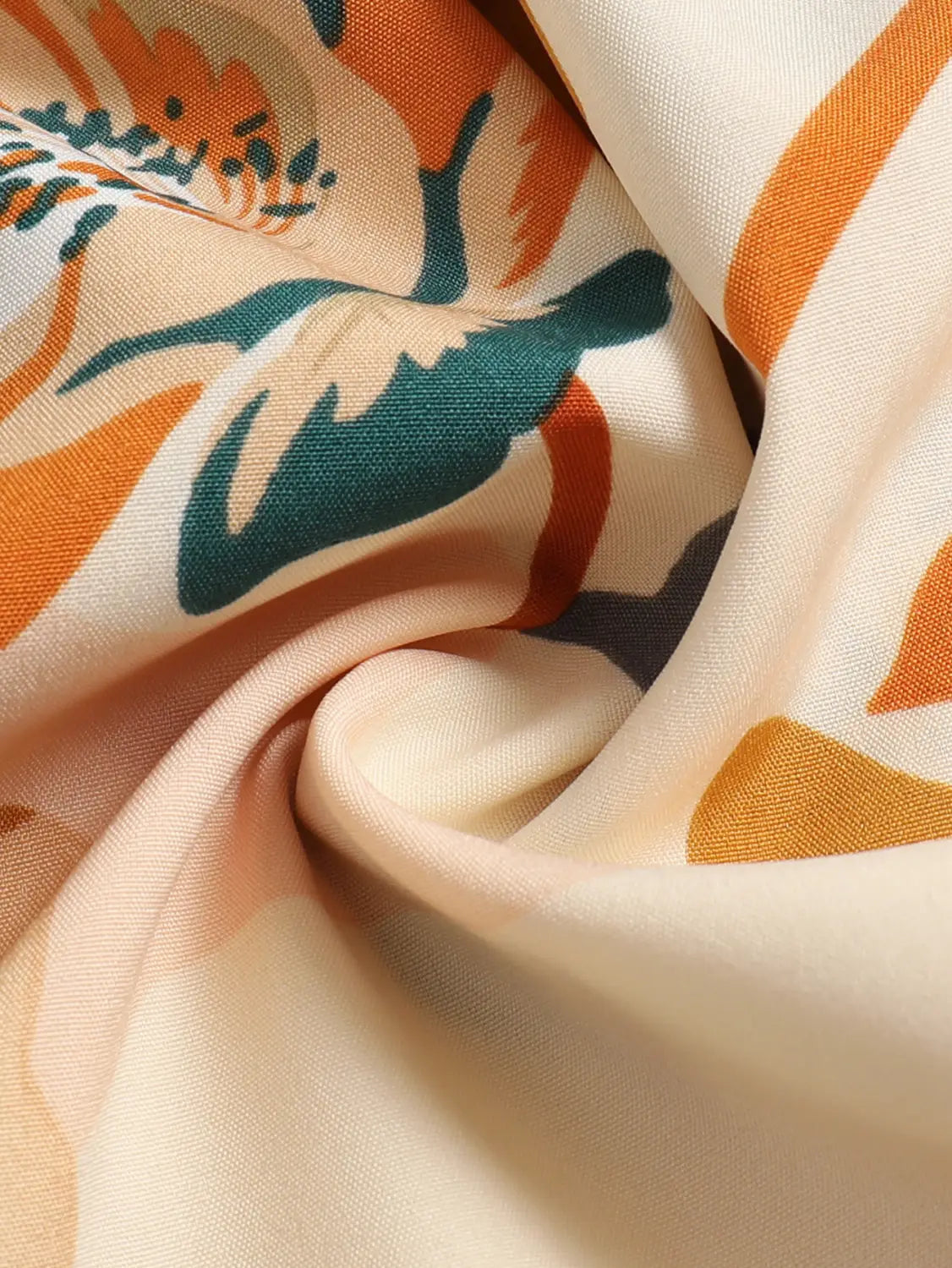 a cream tiered pleated floral print elastic waist skirt paired with a soft cream-colored silk scarf featuring a vibrant pattern of orange and teal stylized flowers