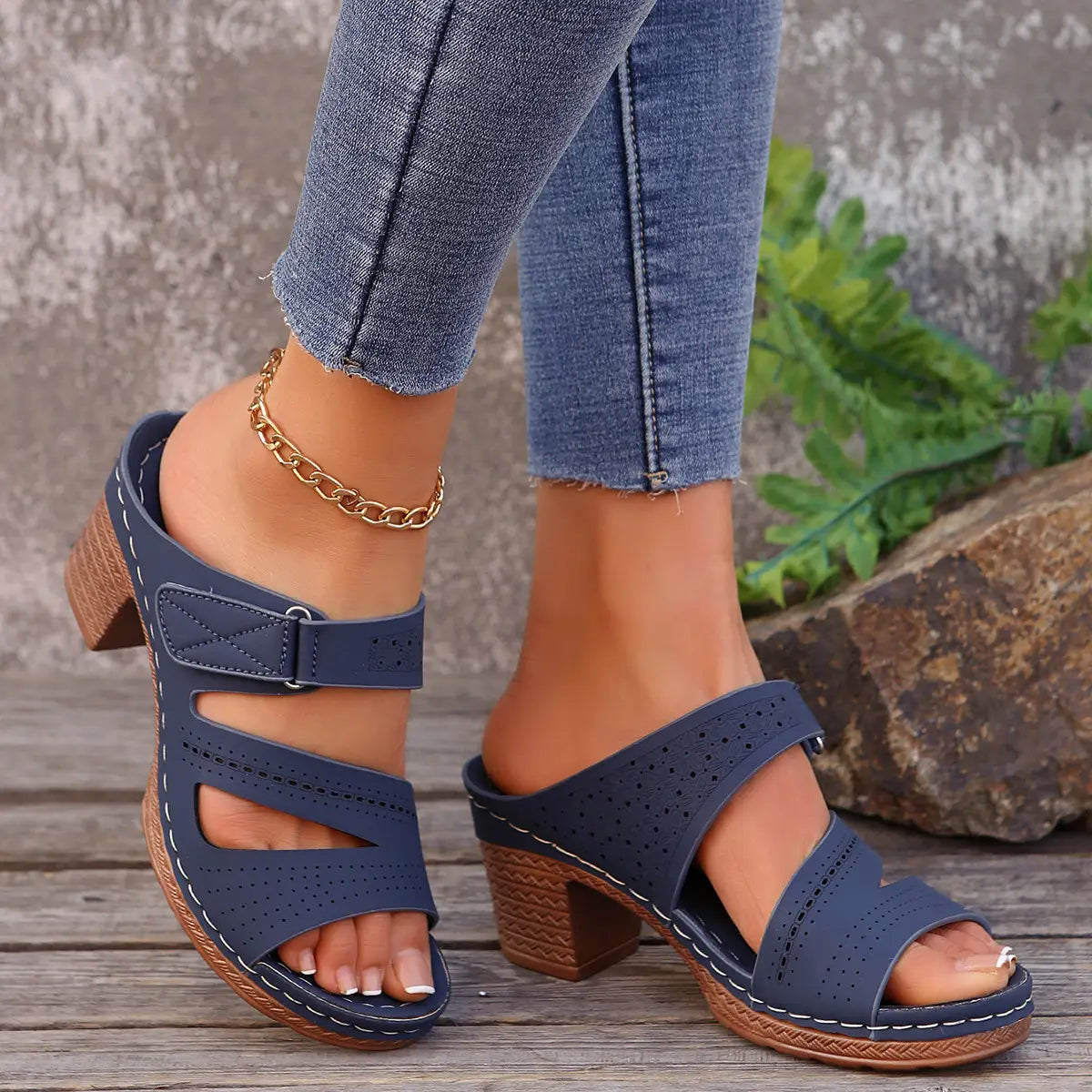 Navy blue perforated leather sandals with a textured block heel and white stitching perfect for summer casual chunky wear.