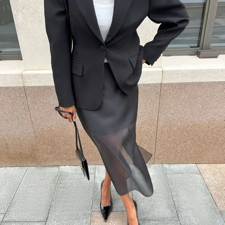black sheer high waist slit sheath skirt paired with a solid black blazer and matching heels showcasing a stylish waist slit sheath look