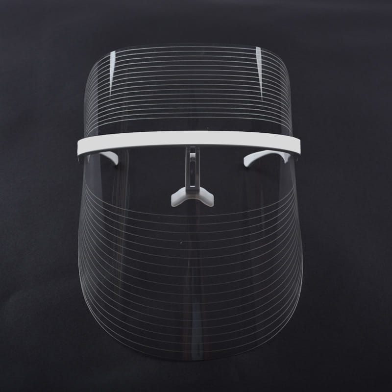 clear plastic face shield with white adjustable headband and central clasp for multifunctional facial massager led beauty mask used as a lifting tool massager and facial beauty aid