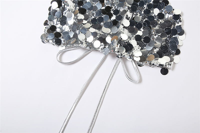 A silver halter backless sequined vest featuring a shimmering silver and black sequined headband with a delicate bow at the center.