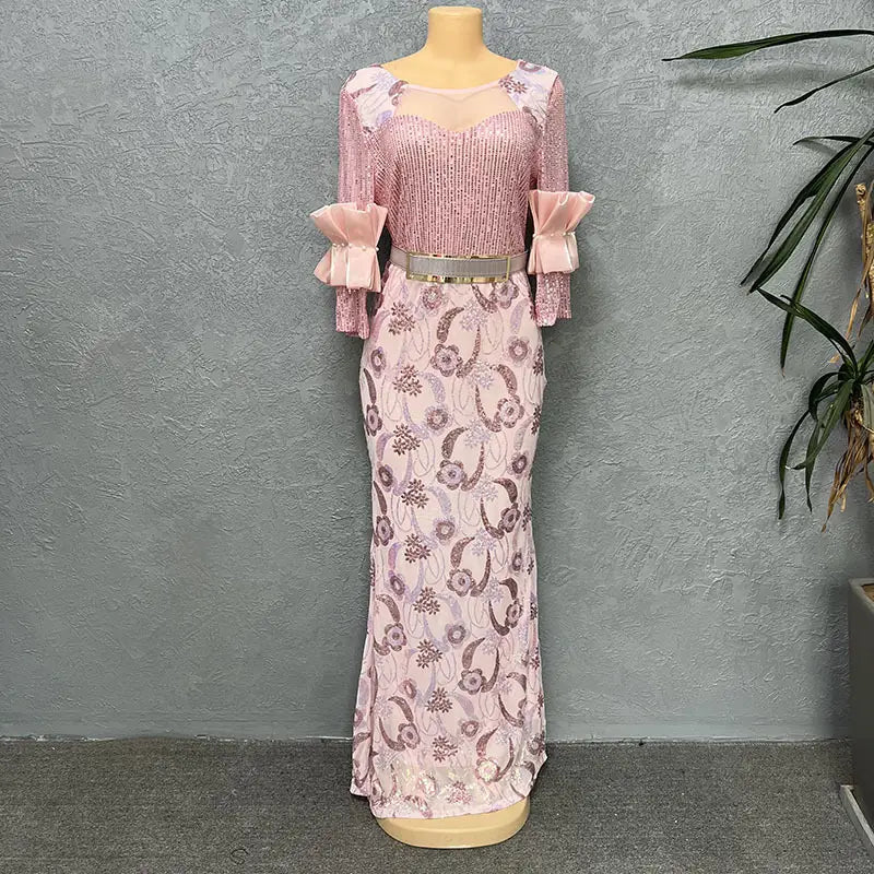 A pink half sleeve slim floral evening dress featuring a round neck shirt design with sequined lace fabric, ruffled sleeves, a sheer neckline, and an ornate floral pattern.