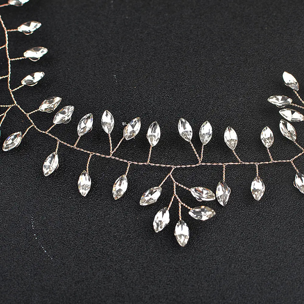 A delicate horse eye silver flexible chain wedding hair accessory featuring a silver-toned vine adorned with clear faceted crystal leaves.