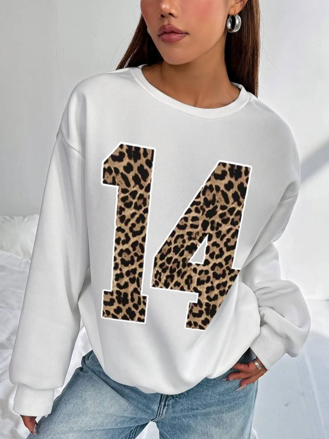 white crew neck sweatshirt featuring a bold black leopard-print number 14 on the front