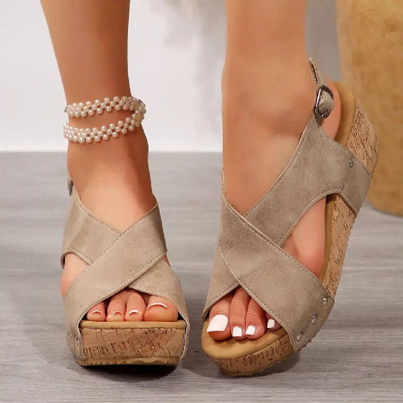 beige suede rivet wedges snadals featuring fish mouth design with cross straps, cork soles, and silver buckle accents