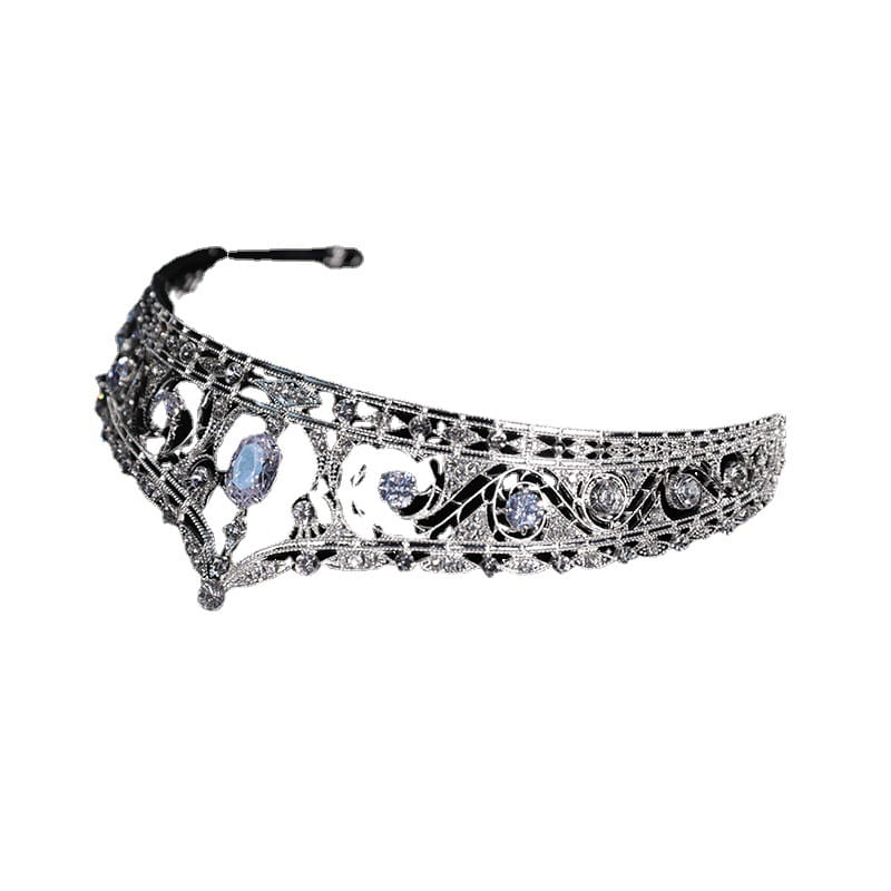 An ornate silver filigree bridal crown with intricate design and clear and light blue gemstones ideal for wedding makeup european-style.