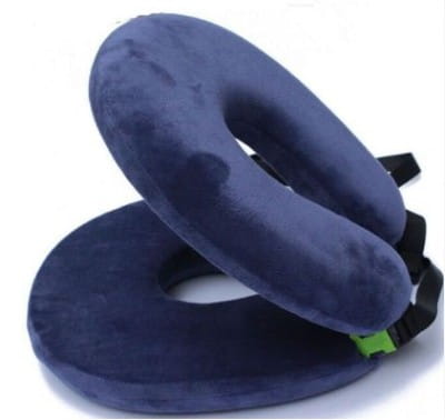 Navy blue plush cervical foldable travel pillow with black adjustable straps and a circular design for comfortable foldable travel.
