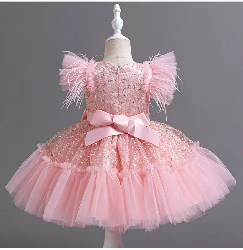 A sparkling pink tutu wedding dress tulle with feathered shoulder accents and a satin bow at the waist featuring a dress tulle skirt summer design.