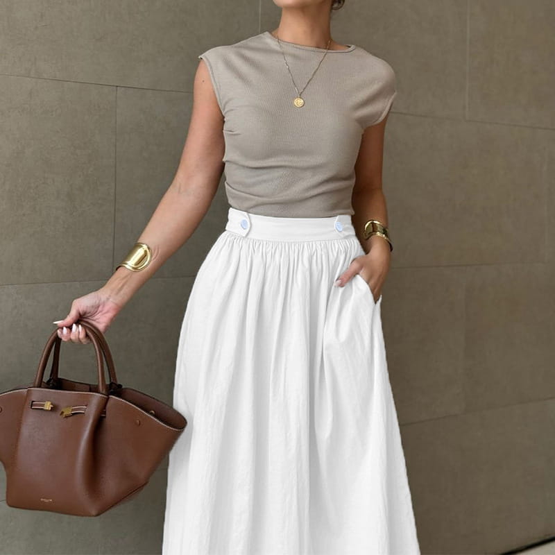 brown leather handbag with gold tone hardware and structured handles complementing a white cotton linen slimming large hem midi skirt