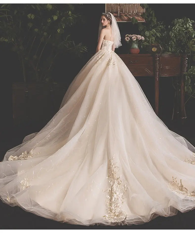 a flowing ivory bride summer tube gown with intricate gold floral embroidery on the bodice and mori style trailing skirt crafted from layered tulle