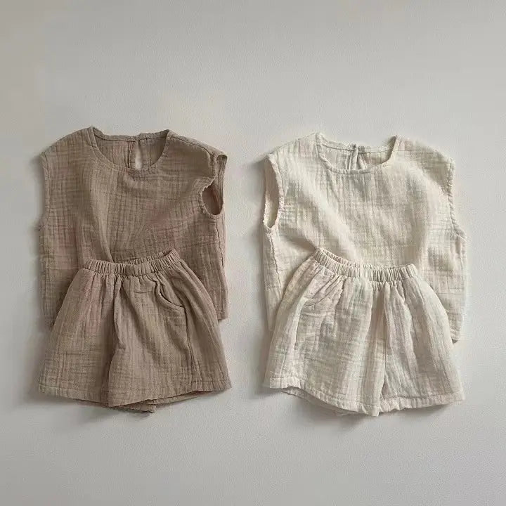 two matching breathable vest shorts sets in muted beige and off-white made from soft textured cotton muslin fabric