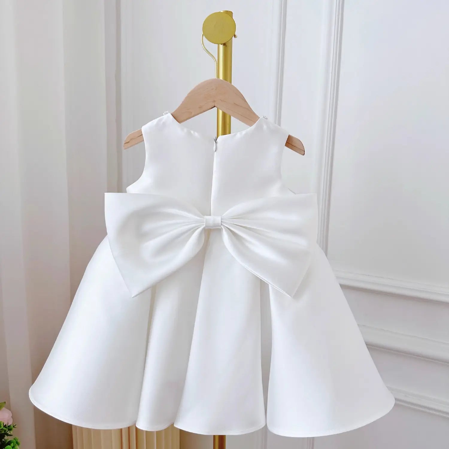 white satin long sleeve baby dress in dress white classic style showing the back side with a large bow detail