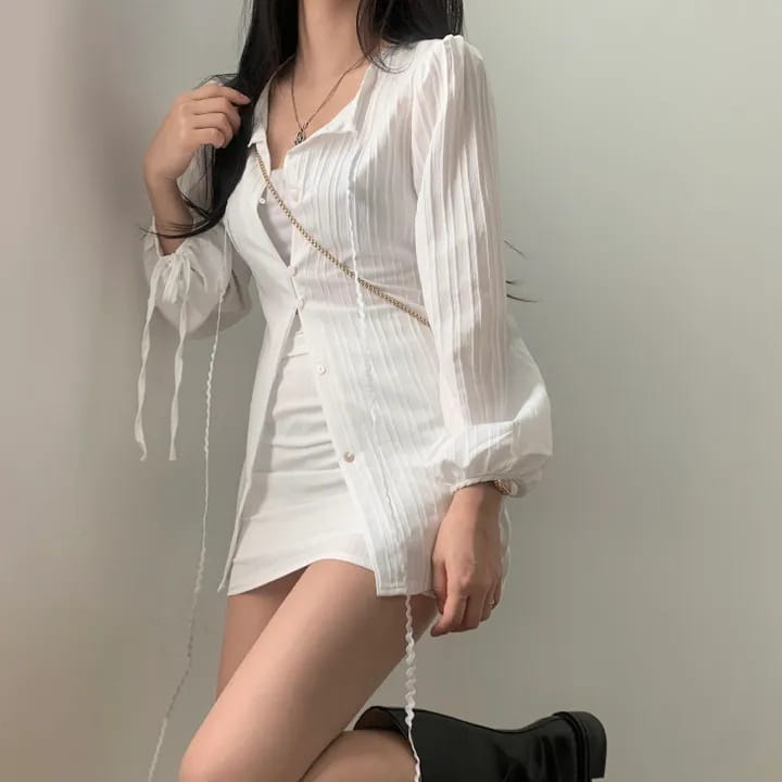 White ribbed long sleeve shirt dress featuring button-up front tie waist and chain strap detail on the sleeve cuffs