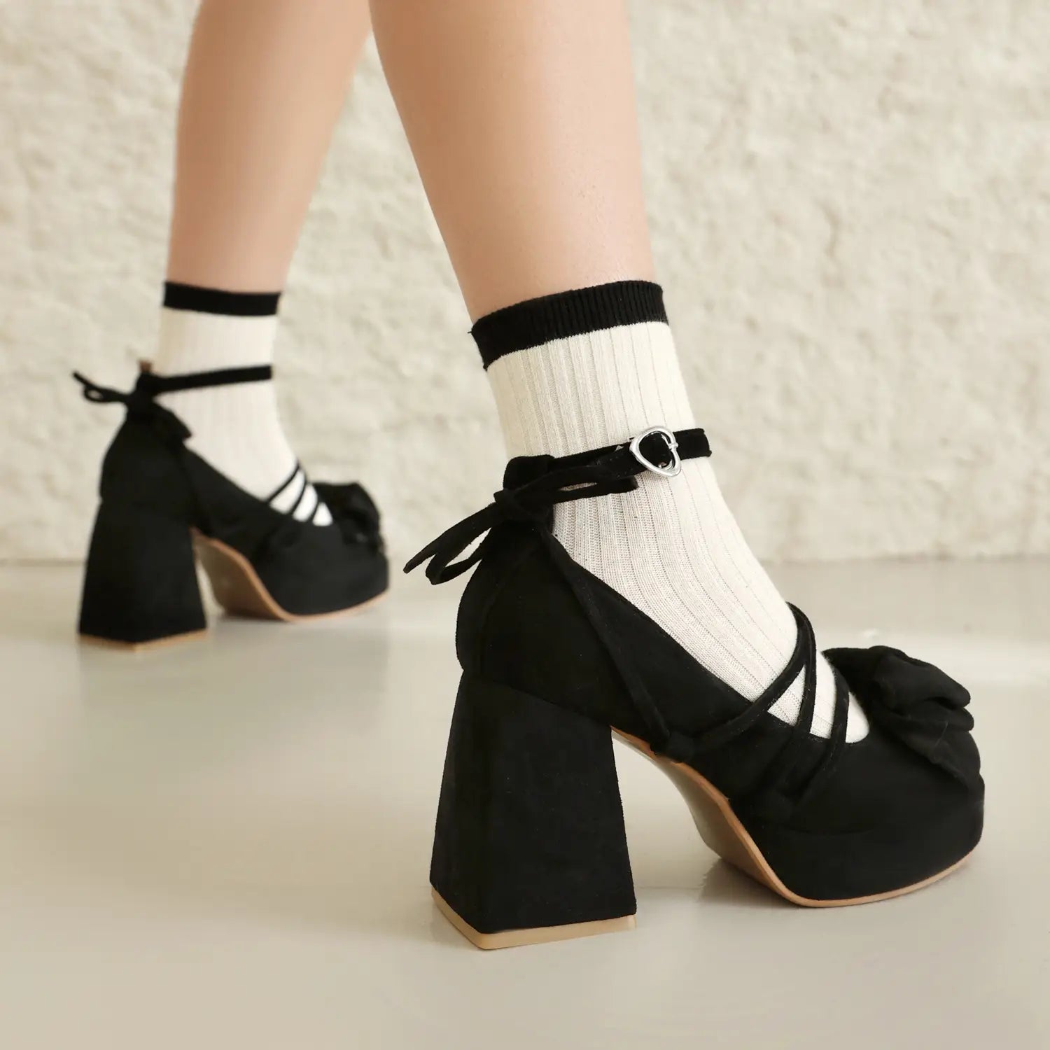 Black platform lolita heels with a square block heel, crisscross straps, and a small size bow at the toe.