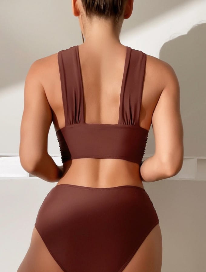 back view of a brown two-piece swimsuit featuring a ruched back and high-waisted bottom paired with a royal blue cross halterneck pleated swimsuit in solid colour.
