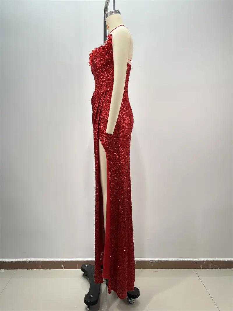 a shimmering red paillette tube evening gown with a high slit and one shoulder design displayed on a mannequin