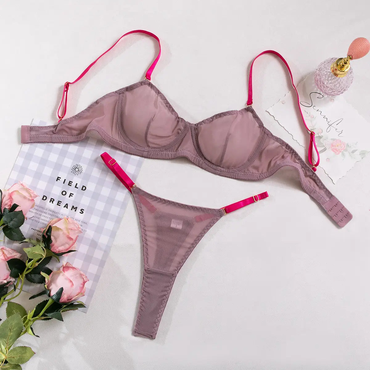 a lavender and pink see-through two-piece set featuring a mauve satin bra and thong with vibrant pink straps made from comfortable fabric.