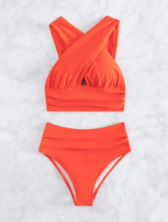 vibrant orange two-piece swimsuit with a cross halterneck top and high-waisted bottoms in a solid colour, complementing the royal blue pleated swimsuit product line.