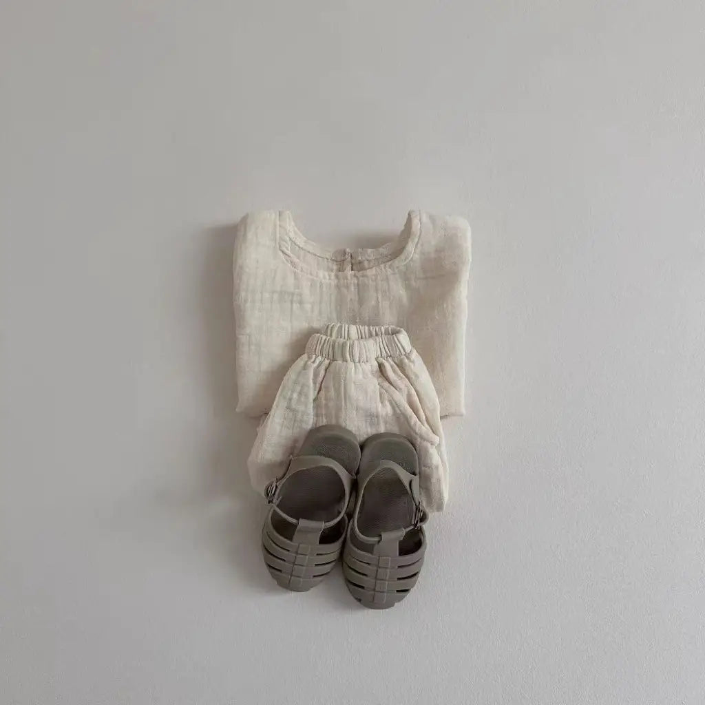 a soft off-white breathable vest made of linen with a simple round neckline and subtle texture, part of a breathable vest shorts set