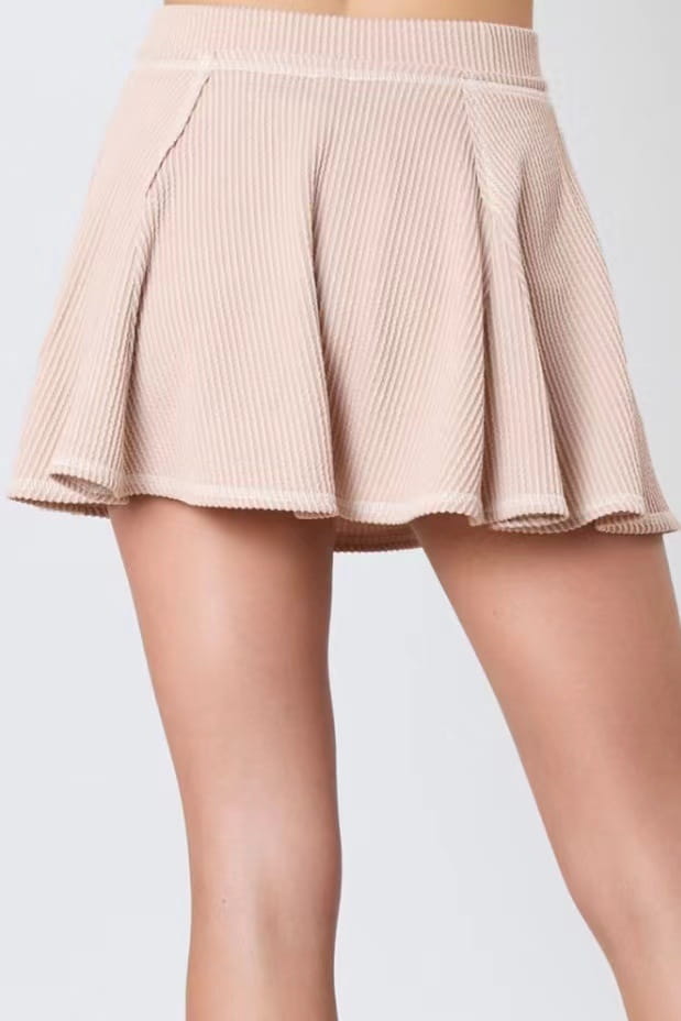 A soft beige pleated corduroy skirt with a ribbed waistband designed for a women’s solid colour ribbed knit casual suit.