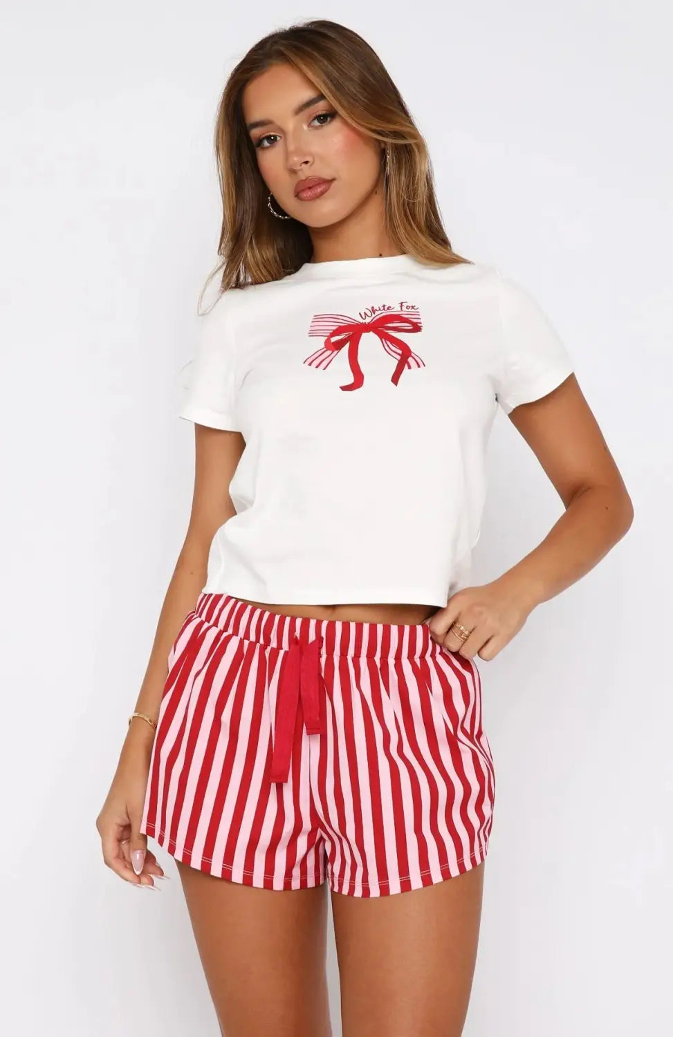 White cropped t-shirt with red bow graphic and white tie text paired with White Fox shorts sweetheart pajamas printing suit.