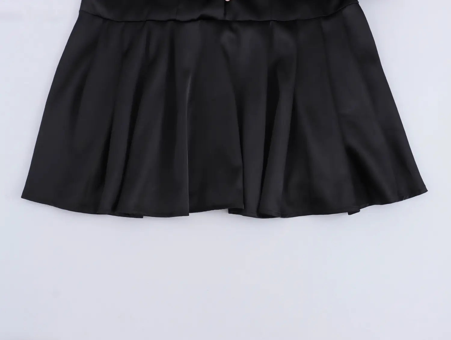black waist pleated skirt made of smooth satin fabric as part of a sweet satin dress with fitted waist pleated design
