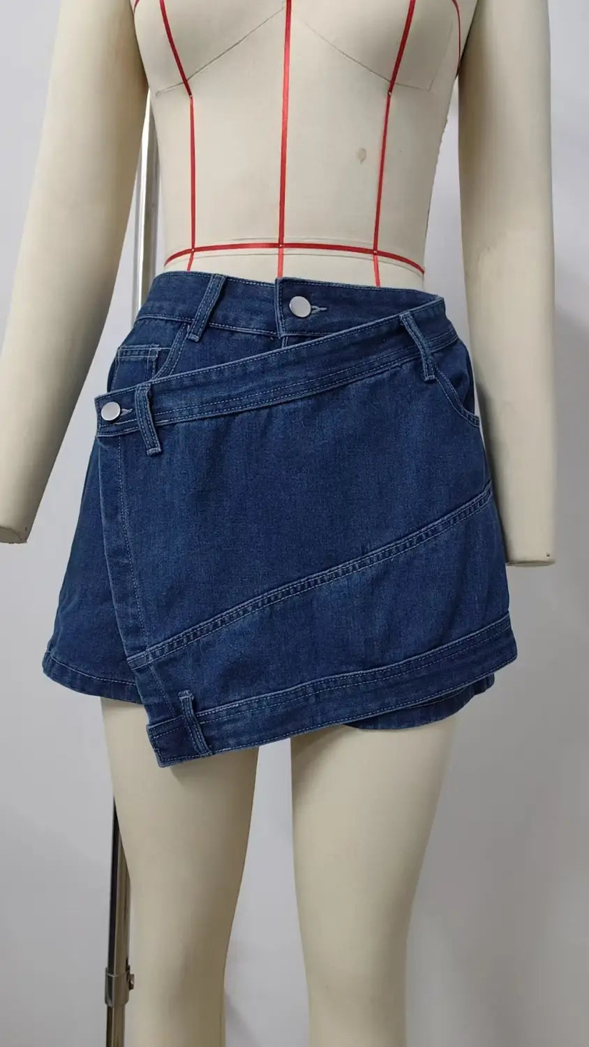 A stylish dark blue high waist washed irregular denim short skirt featuring a modern asymmetrical design and visible stitching details.