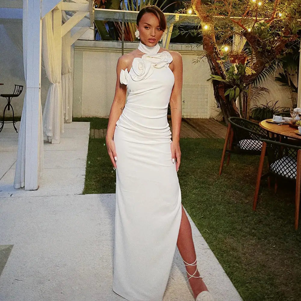 A sleek white satin one-shoulder gown featuring a ruched bodice, high neckline, and a large white ribbon flower embellishment in ribbon flower halter style.