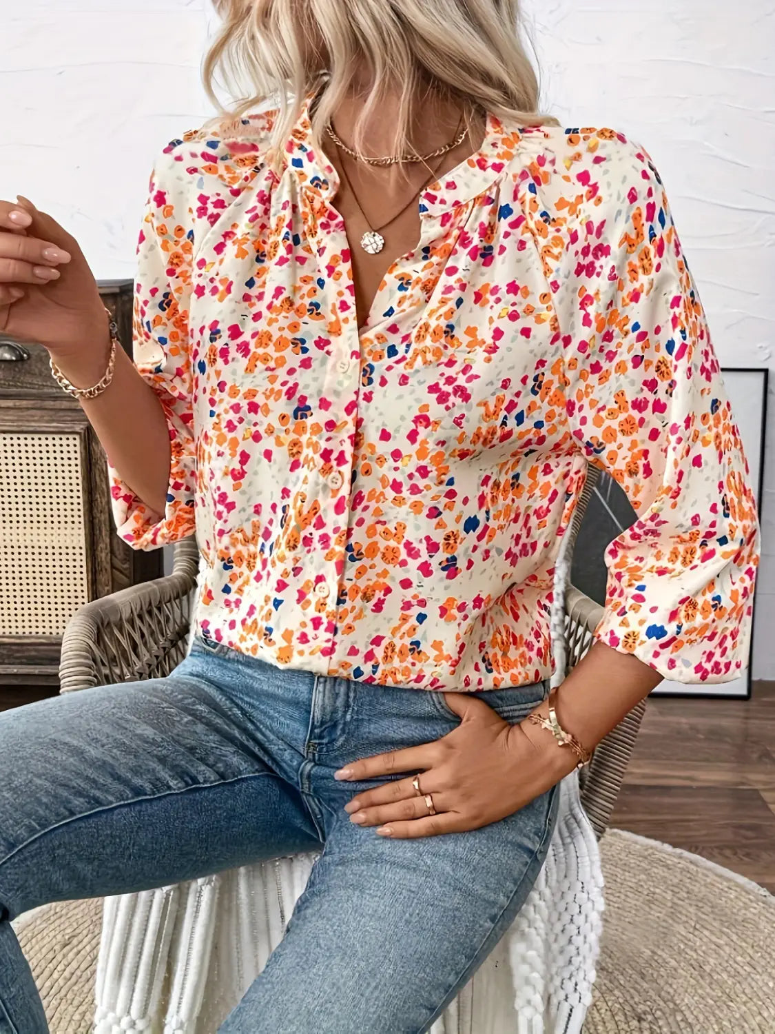 A vibrant cream lantern sleeve floral print v neck blouse featuring colorful orange pink and blue blossoms.