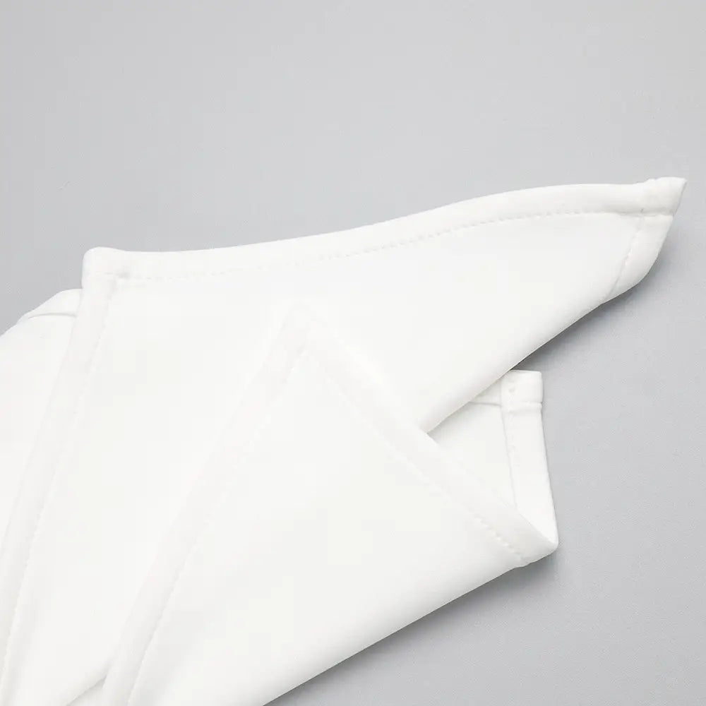 a neatly folded crisp white cotton fabric with soft folds and a clean hem for a satin white ribbon flower halter gown