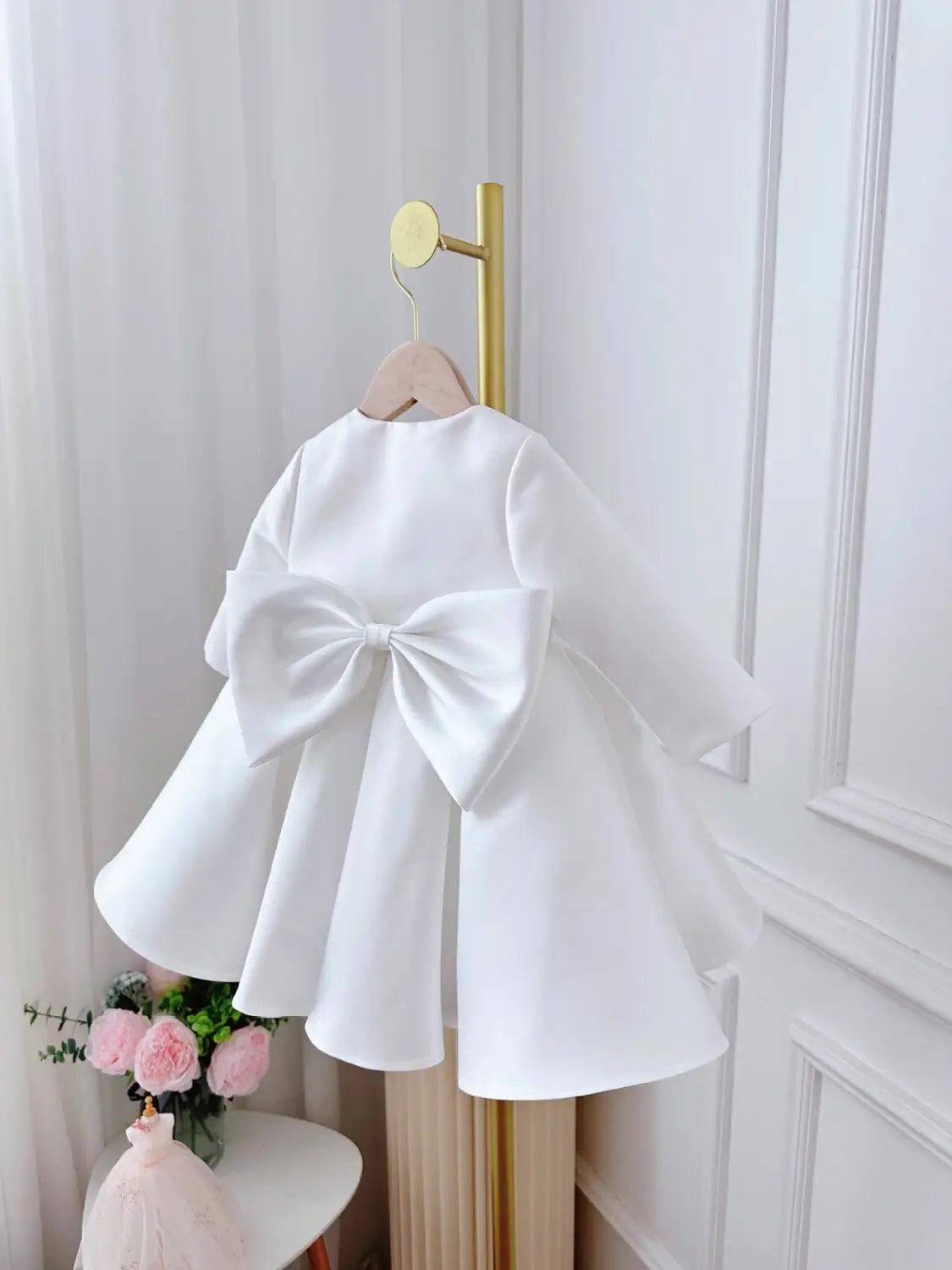 white satin long sleeve baby dress white classic style showing the back with a large bow detail