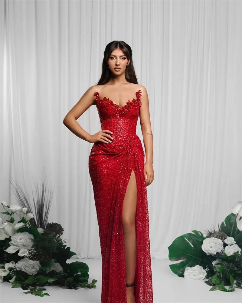 A dazzling red paillette tube gown featuring floral embellishments and a high slit in a high slit red design.