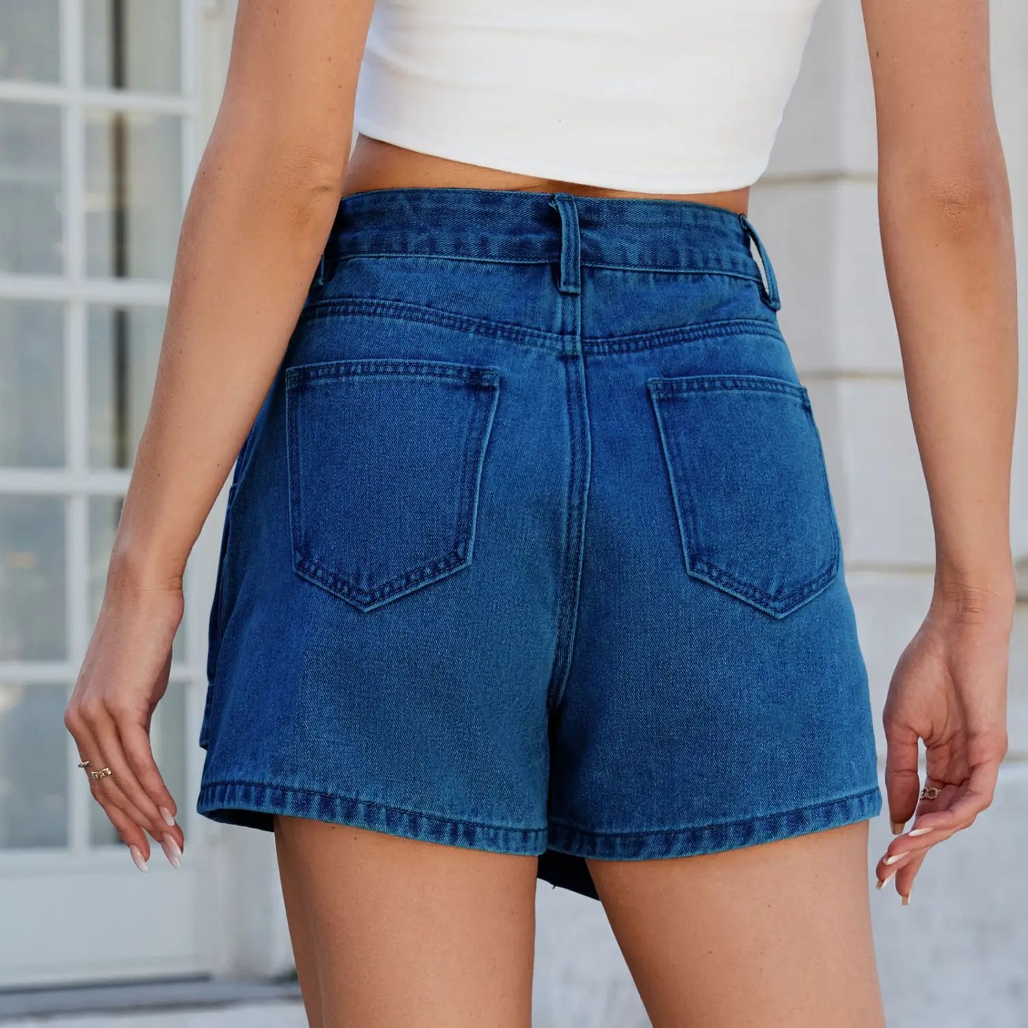 high waist washed irregular denim short skirt in blue denim showing the back side with two pockets