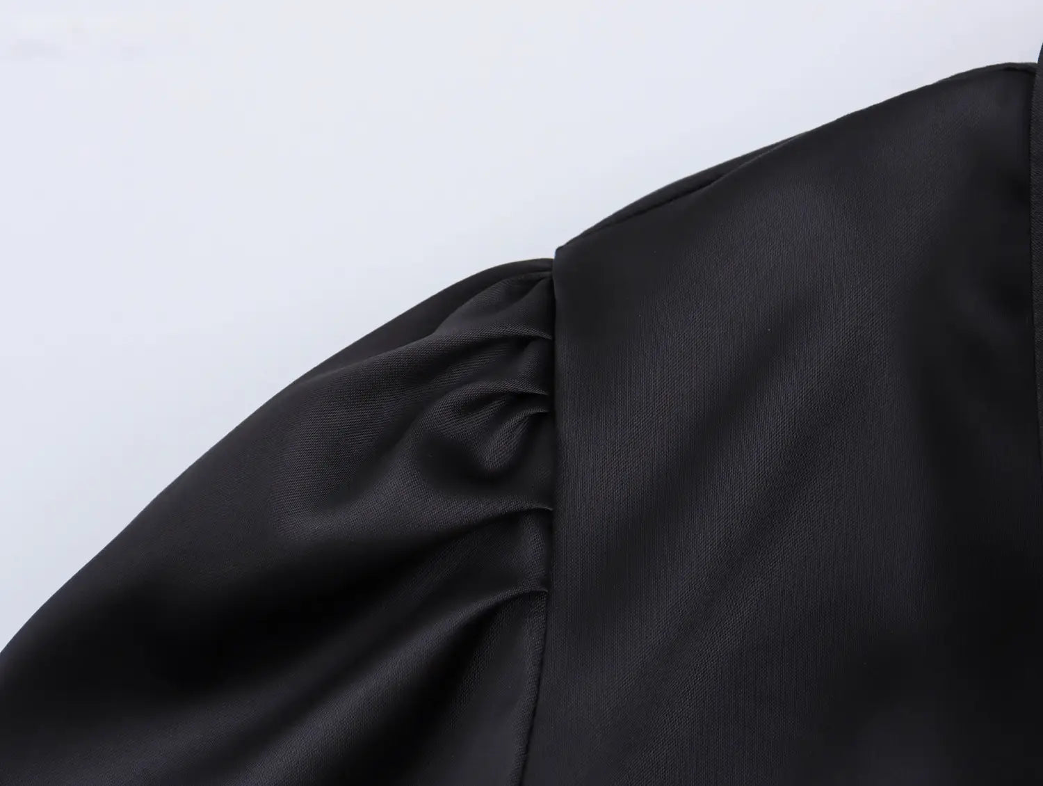 black satin sleeve with gathered puffed design on white sweet satin dress with fitted waist pleated skirt
