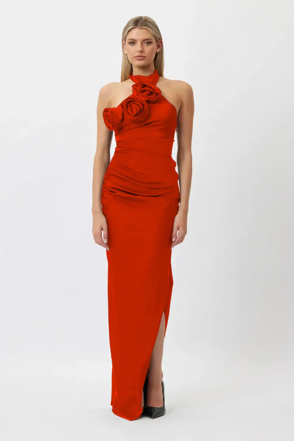 a striking red satin gown featuring a white ribbon flower halter neck with a sculpted rose embellishment and a high slit along one leg
