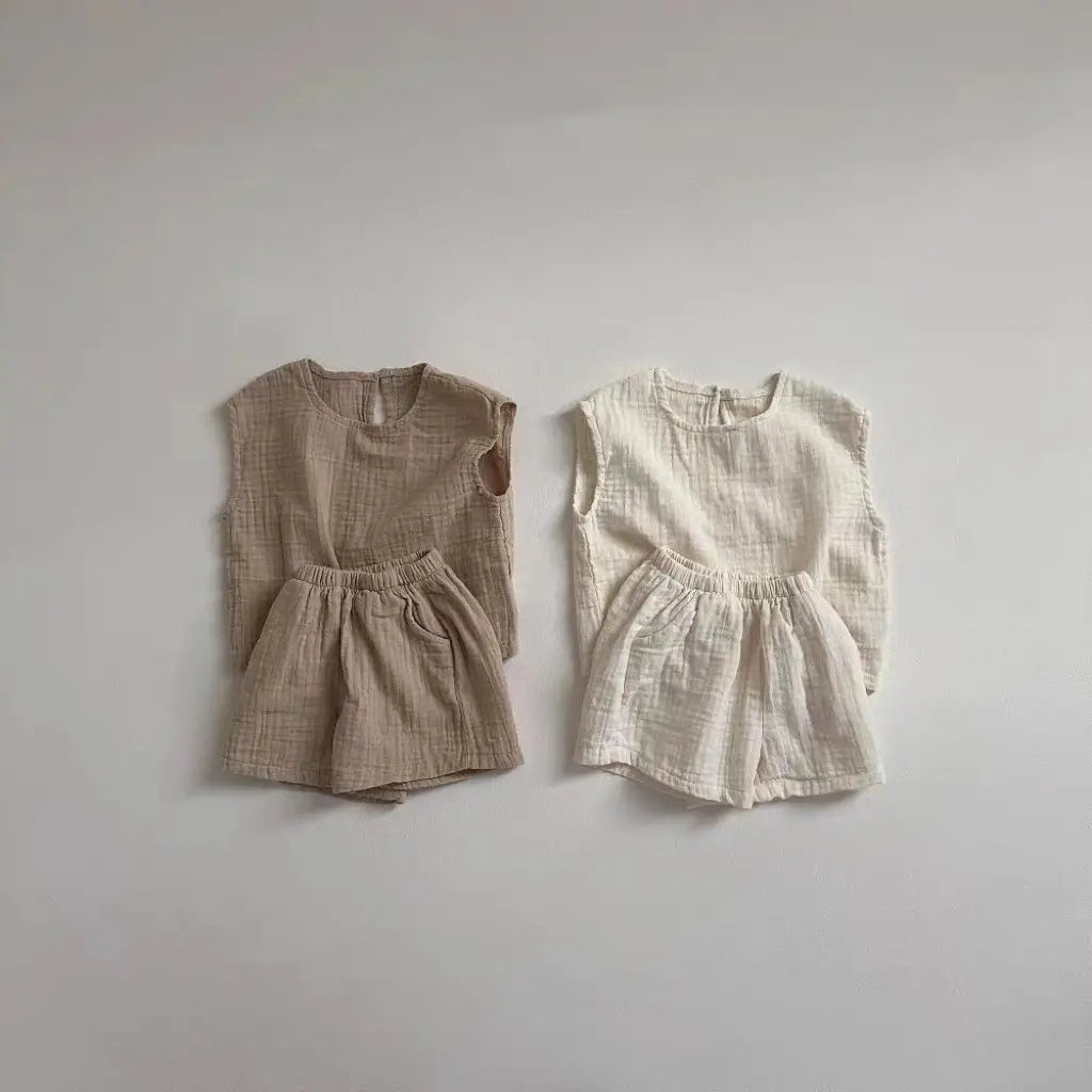 two matching breathable vest shorts sets in muted beige and off-white made from soft textured cotton muslin fabric