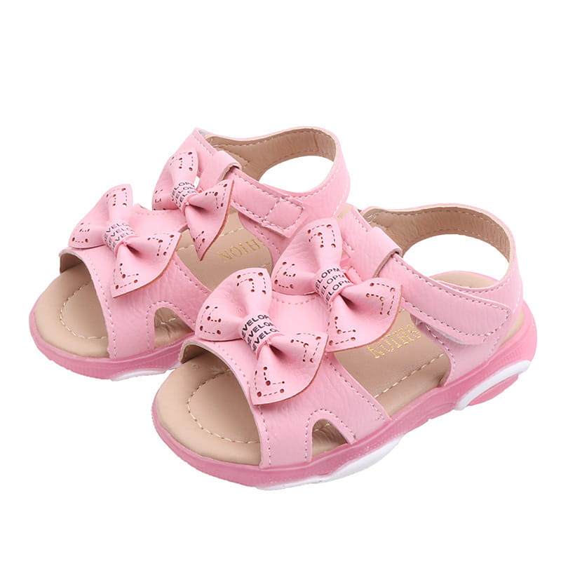 pink children’s sandals with decorative bows and soft padded sole designed as white led flashing princess shoes featuring cute flower flashing lights for a charming look