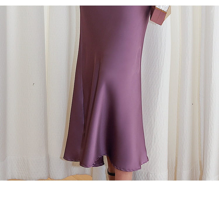 a flowing satin-like purple mermaid-style skirt with a smooth glossy finish and flared hem complementing a blue sleeveless lace sheath dress