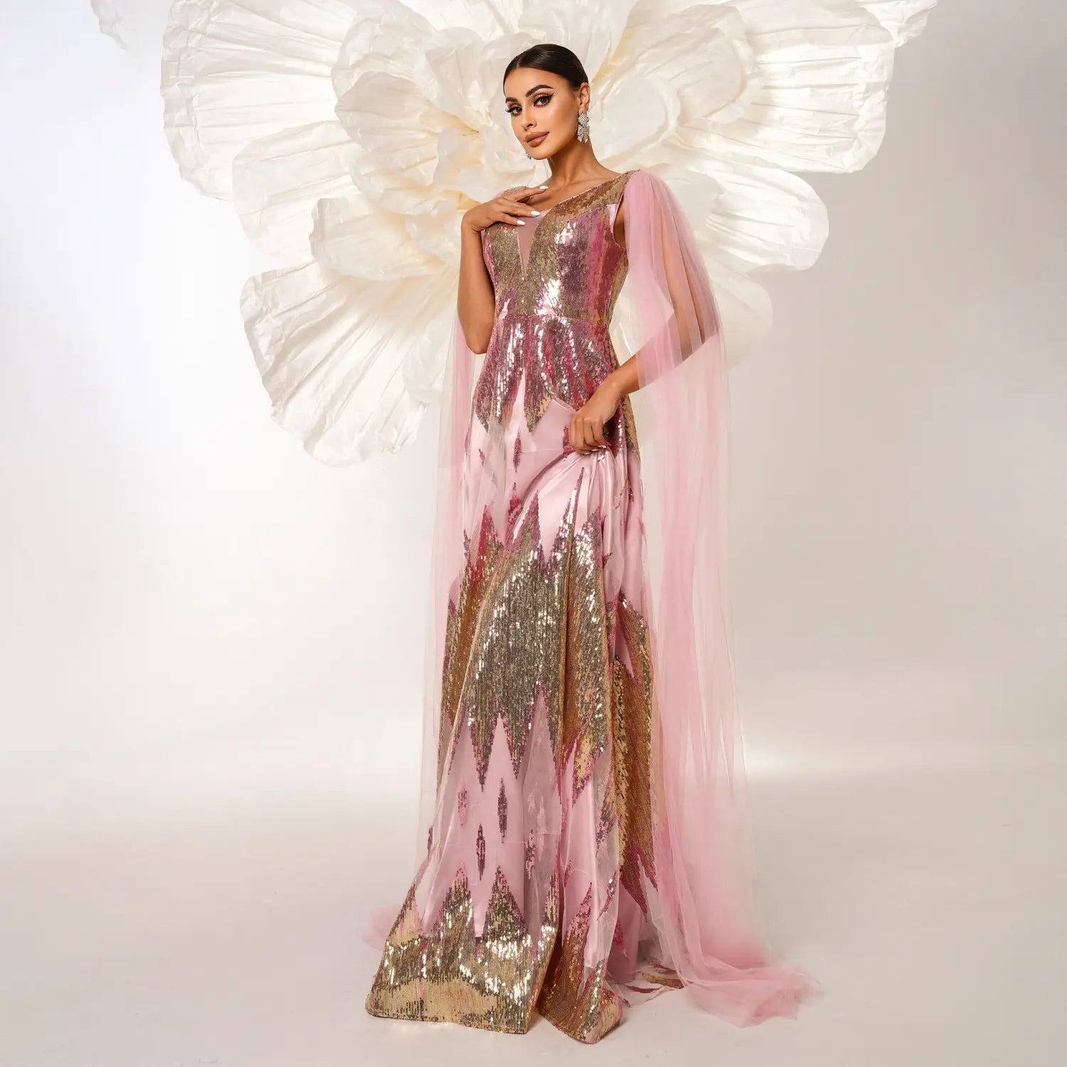 A pink and gold mesh long sleeve sequins large swing dress featuring a shimmering gown with a sheer capelet.