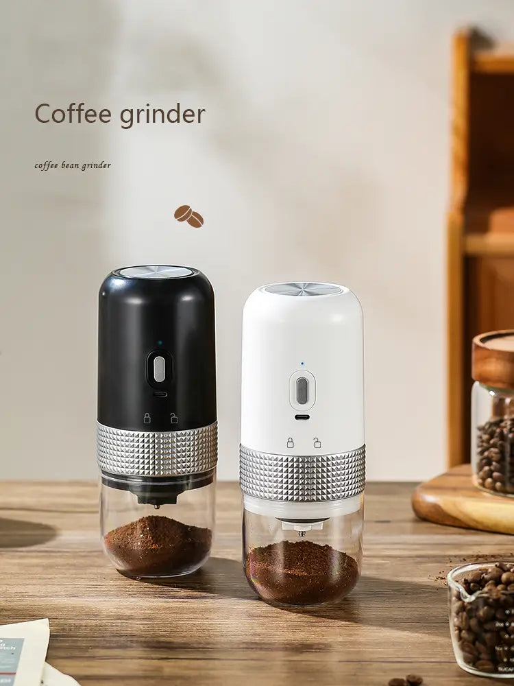 Two sleek compact portable electric ceramic coffee grinders with black and white bodies and silver textured bands around the midsection featuring USB charging.