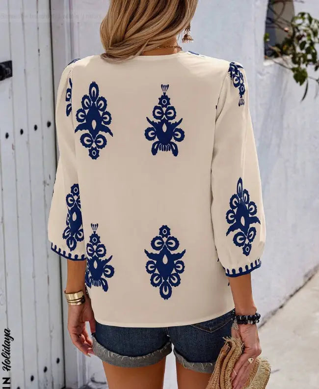 cream-colored casual vacation shirt with navy blue embroidered floral patterns on the back and sleeves suitable for holidaya random print wear