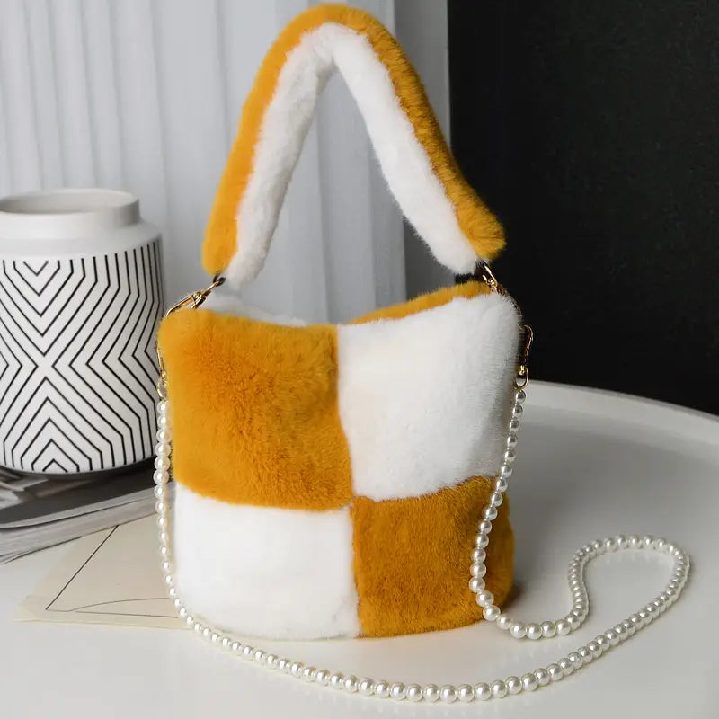 Yellow checkerboard plush bucket bag in mustard yellow and white faux fur featuring a pearl chain design strap.