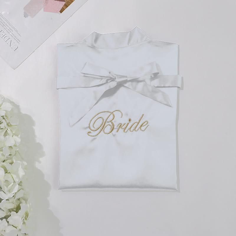 white satin bridal pajamas simulation with gold embroidered bride script and matching satin bow at the neckline in a simulation silk nightgown style