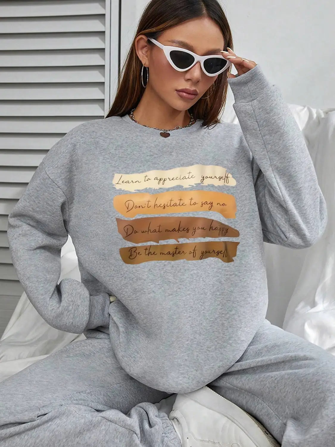 Gray oversized long sleeve sweatshirt with beige and brown horizontal stripes and a motivational quote printed across the chest for solid colour daily wear.
