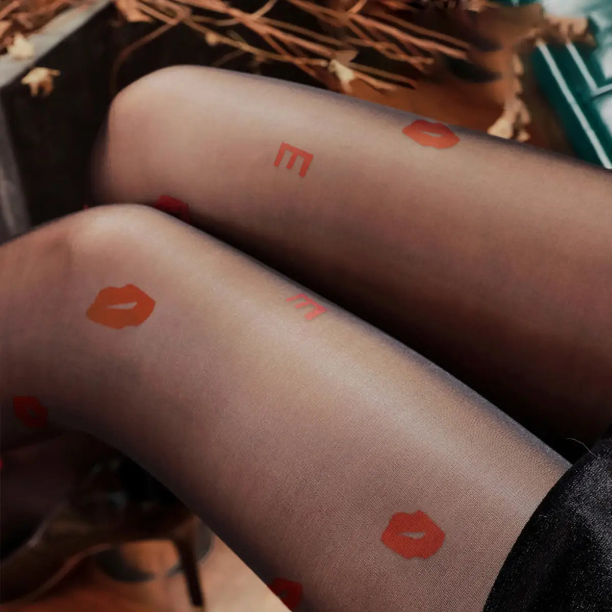 black snagging resistant sock leggings featuring translucent black tights with vibrant orange lipstick prints and lettering