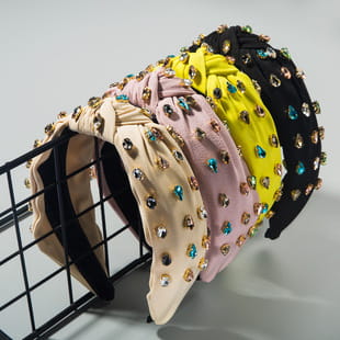 A collection of baroque colorful headbands with knotted design and sparkling rhinestone accents.