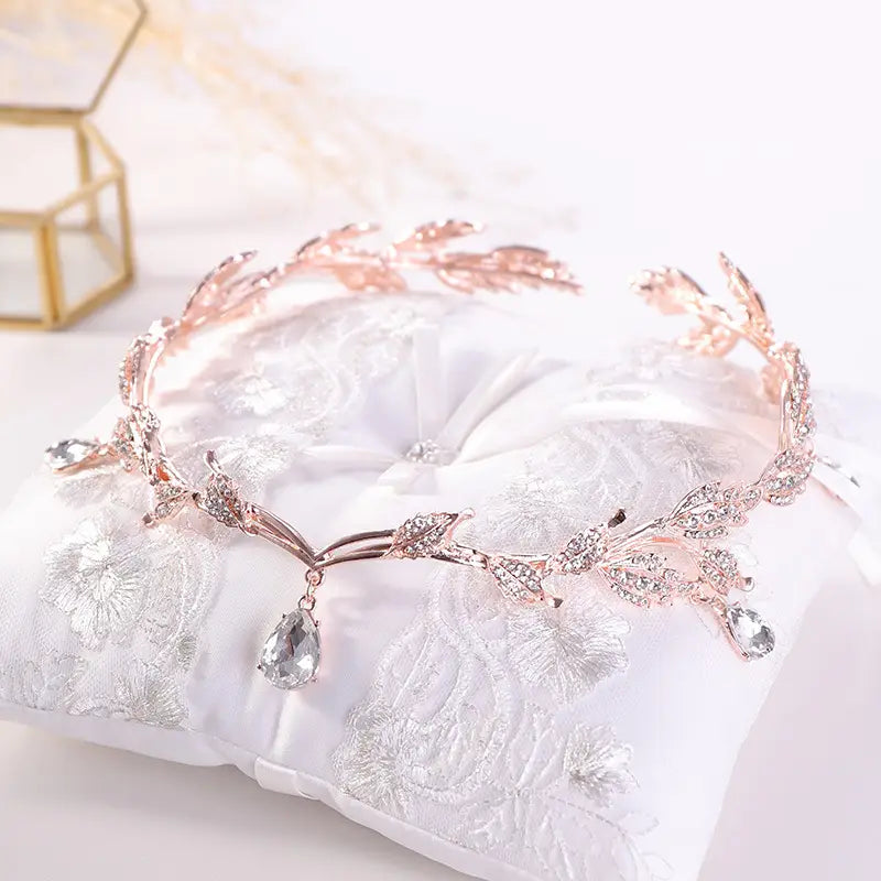 A delicate rose gold golden crown headband adorned with sparkling clear crystals and dangling teardrop pendants perfect as a crown headband wedding or headband wedding headdress.
