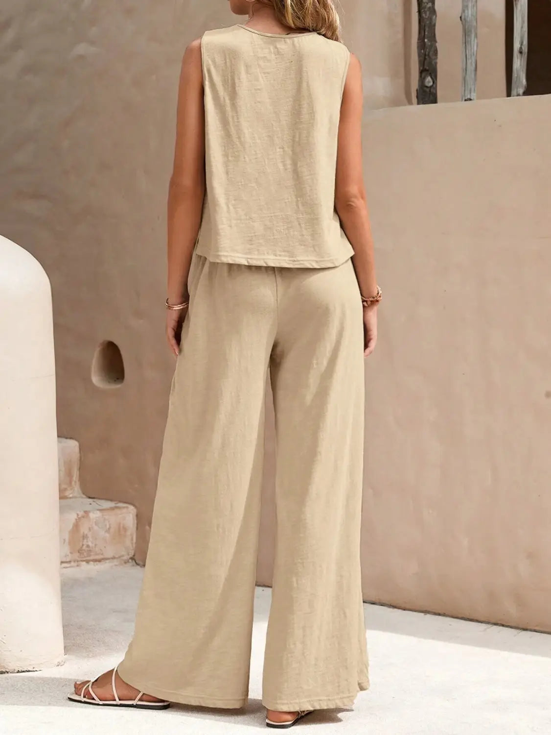beige sleeveless top with a relaxed fit and subtle texture paired with black casual loose pants in a casual loose pants set