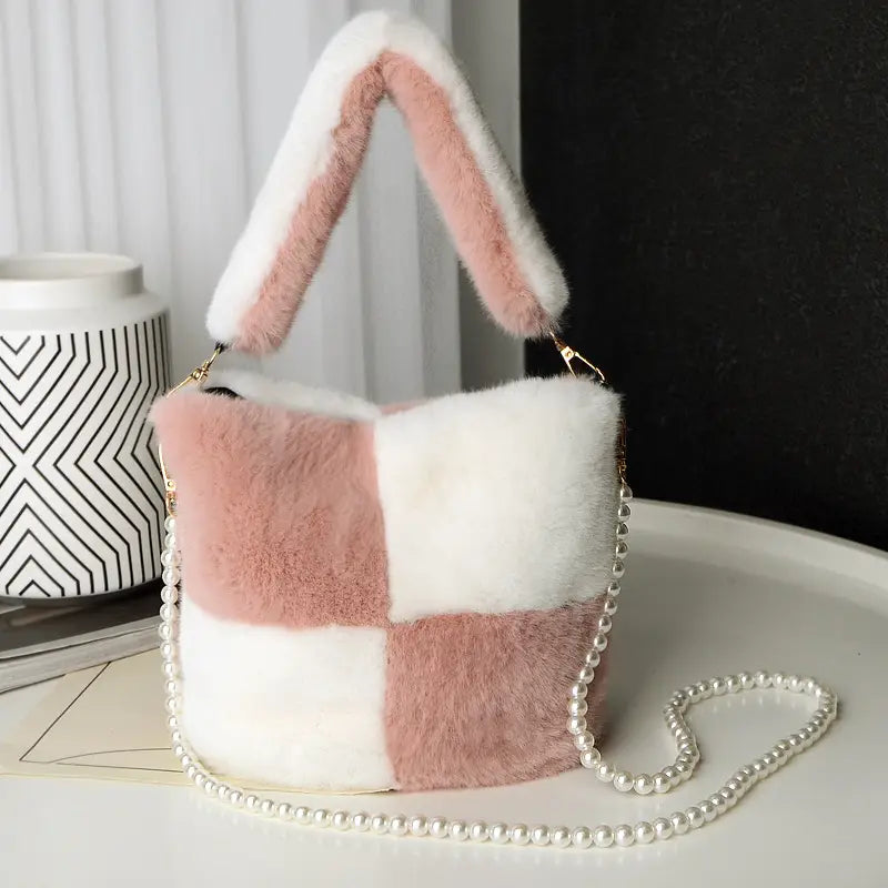 yellow checkerboard plush bucket bag in soft pastel pink and white faux fur with a matching pearl chain design strap.